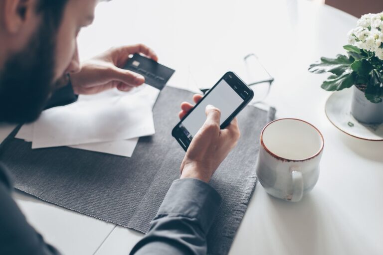 Homem confere no celular como aumentar limite do cartão de crédito