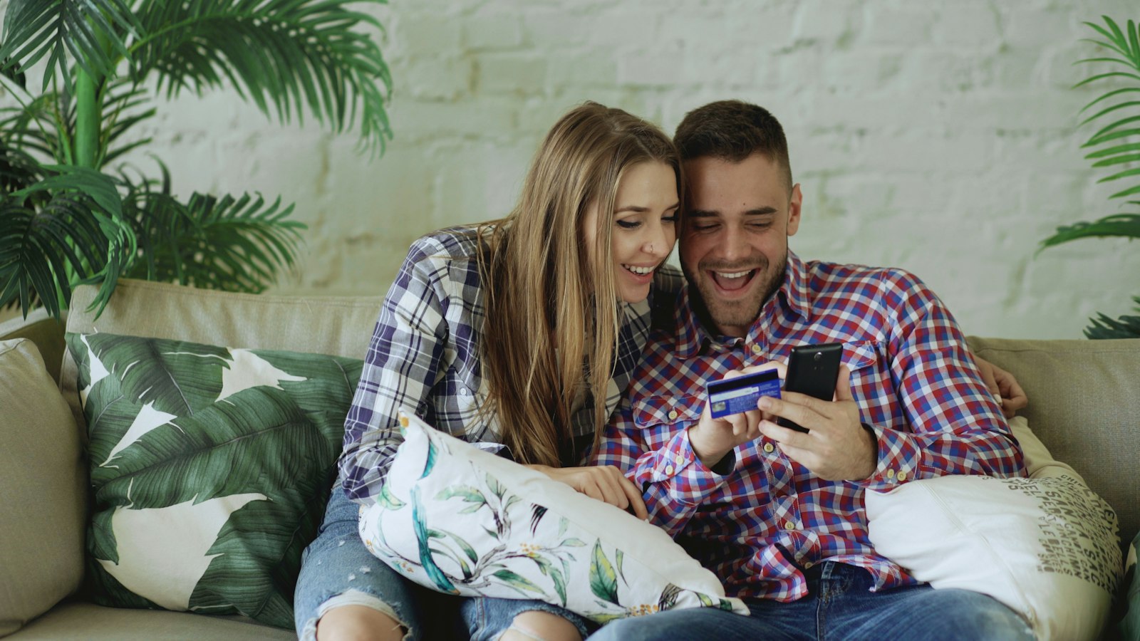 Casal comparando compras no celular com cartão adicional compartilhando o limite do titular