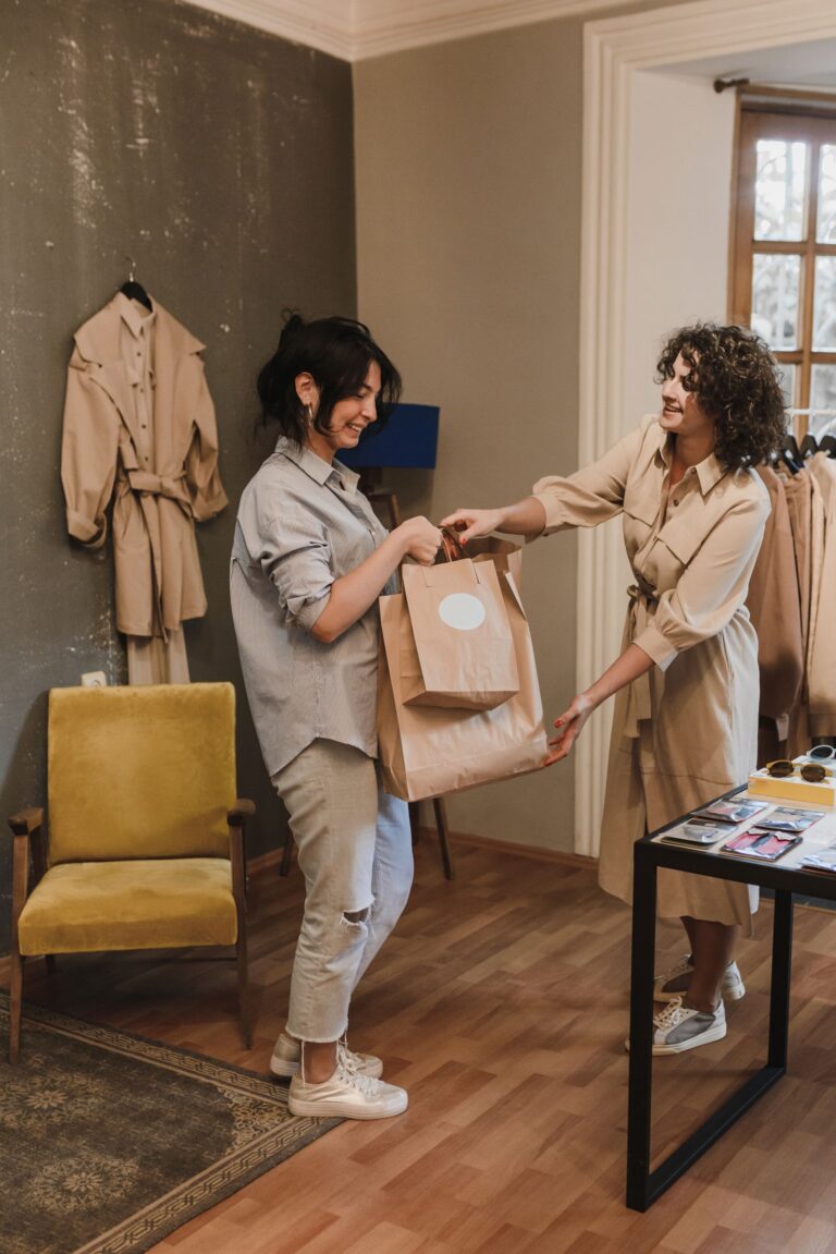 Cliente em loja de roupas com sacolas na compra, ilustrando o cartão de loja
