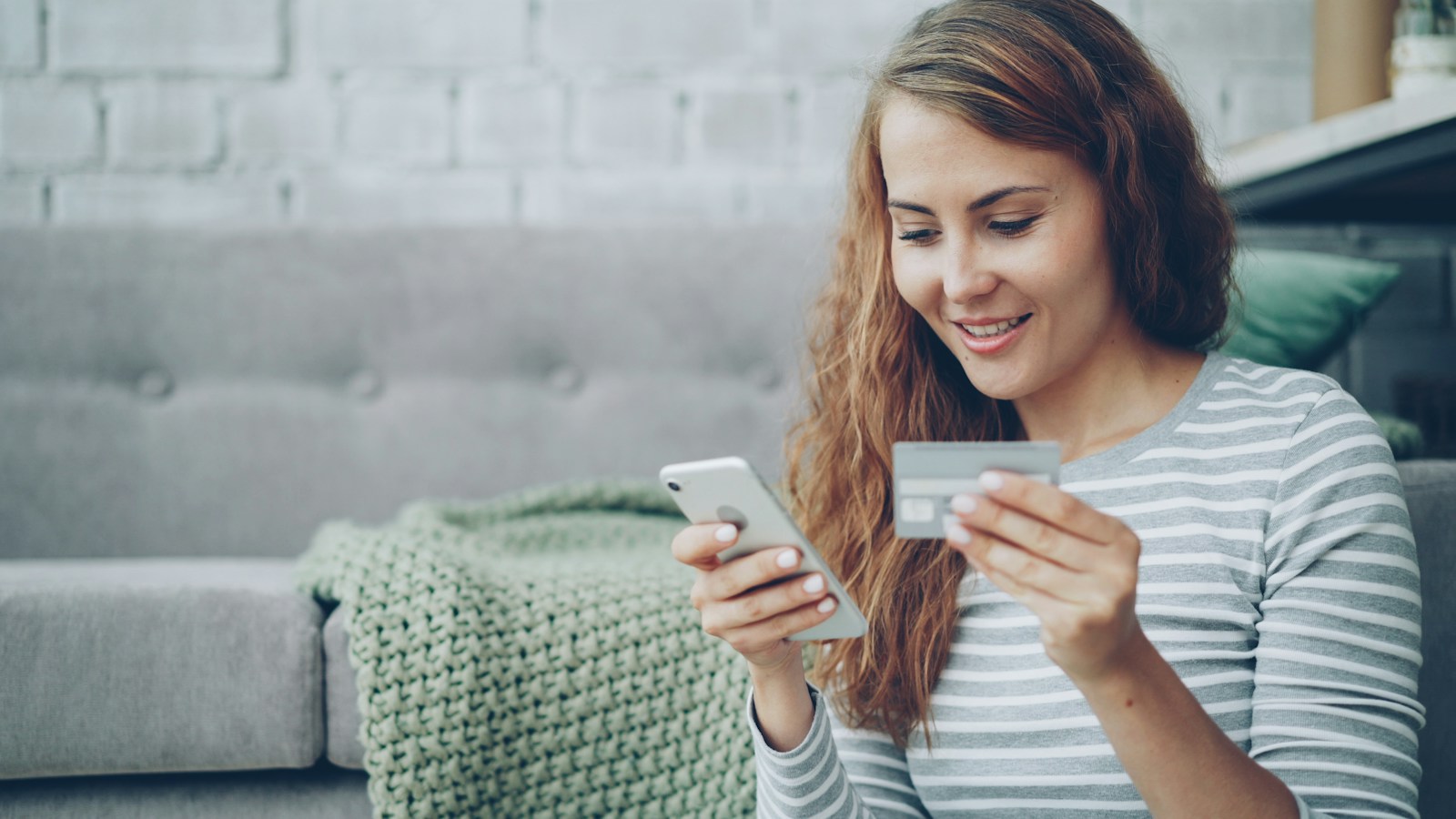 Mulher compara a conta global e o cartão para fazer compras em sites internacionais
