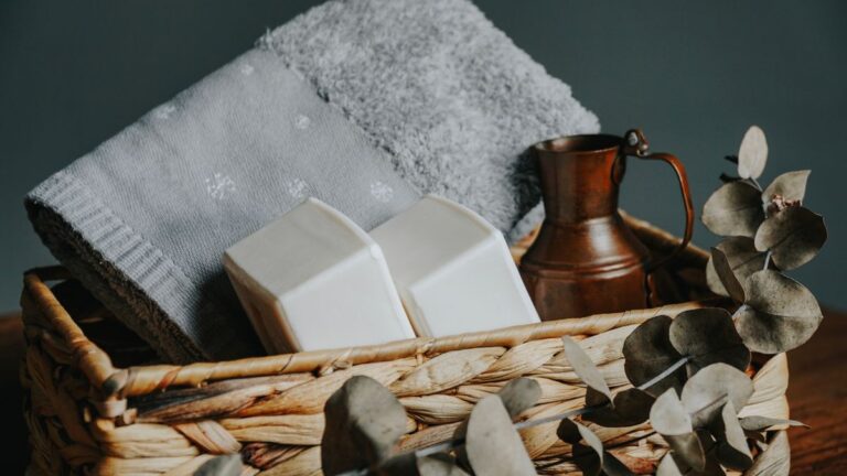 Kit de autocuidado em cesta de palha com toalha, sabonetes e folhas de eucalipto