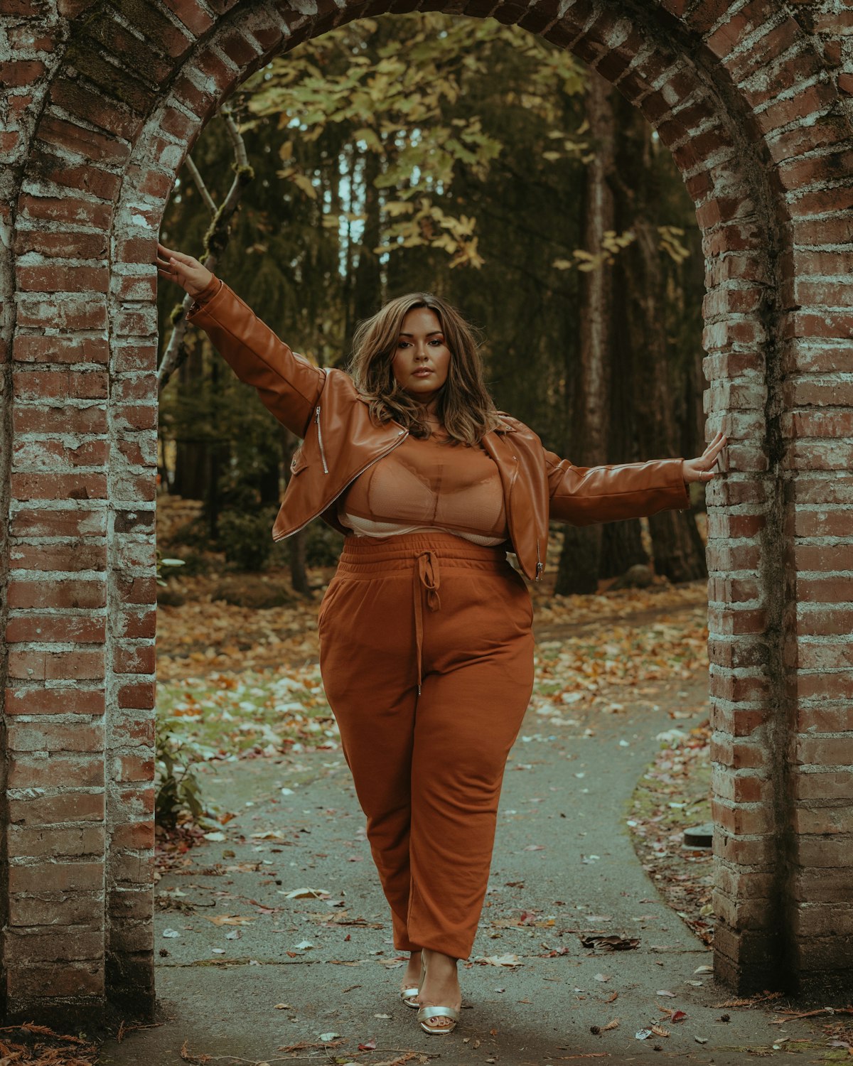 Moda plus size barata: mulher com conjunto de moletom terracota e jaqueta de couro sintético