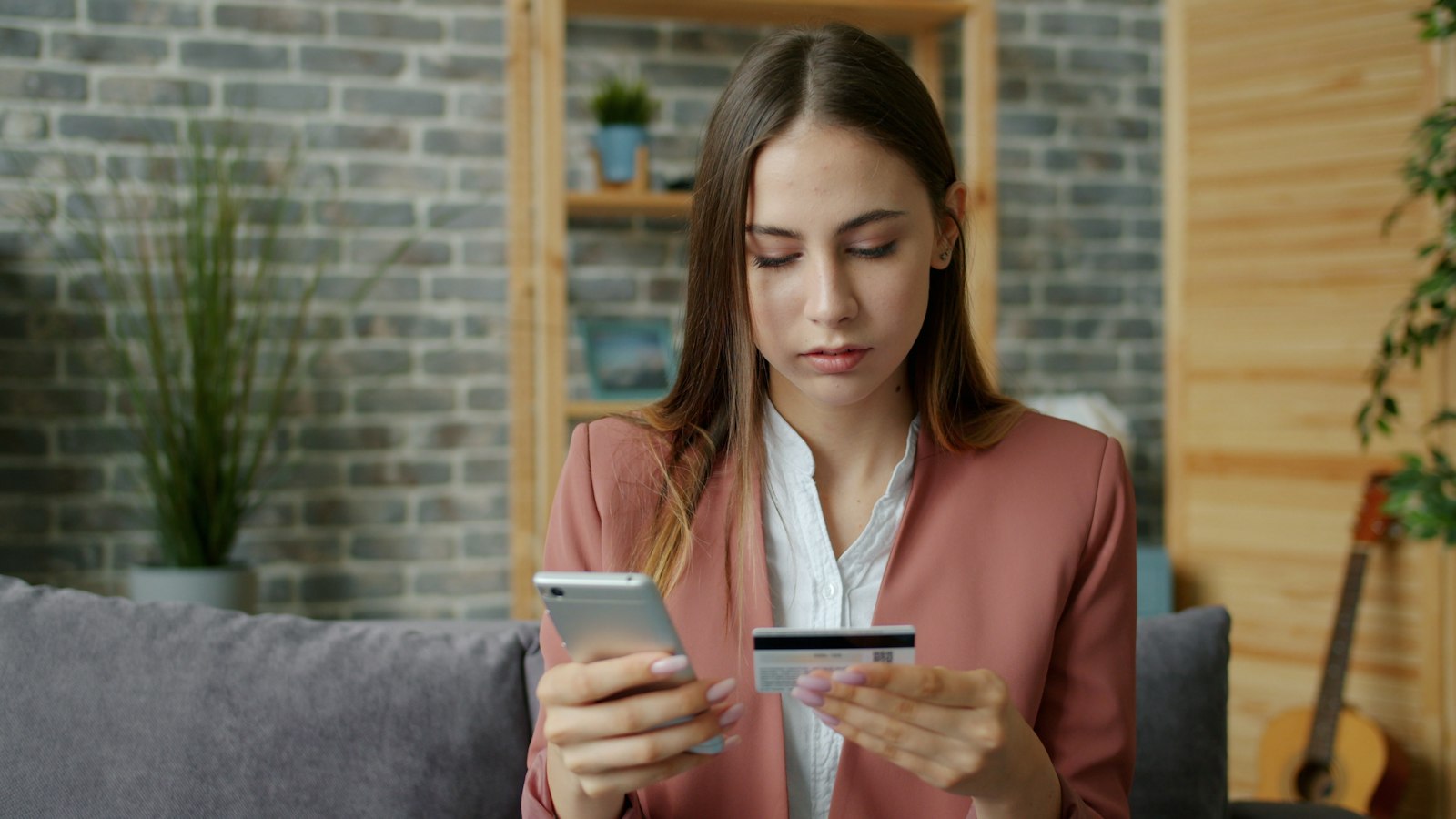 Mulher avaliando o pagamento seguro em compras online com celular e cartão