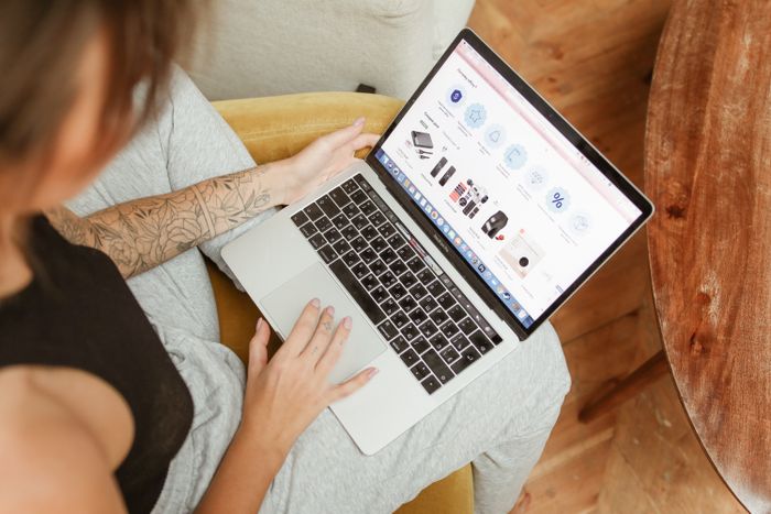 Mulher comprando no notebook, ilustrando um programa de cashback