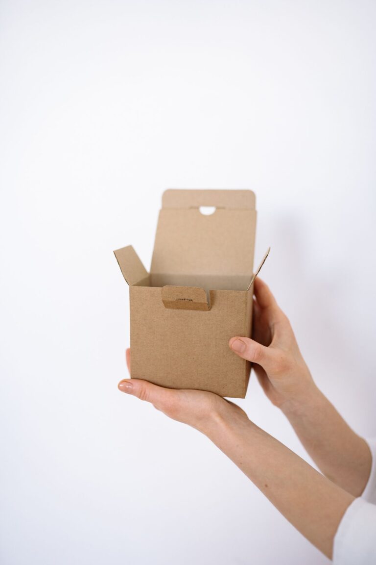 Mãos segurando caixa de papelão para rastrear encomenda