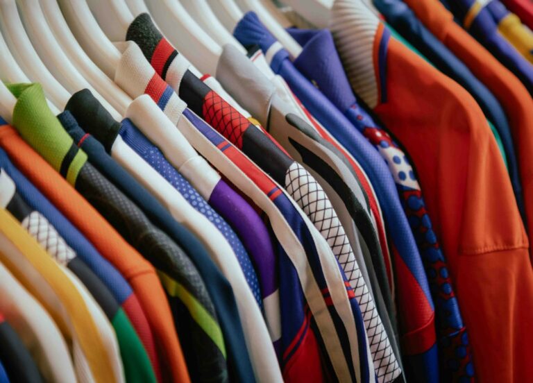 Revenda de roupas: peças coloridas organizadas em cabides para vender
