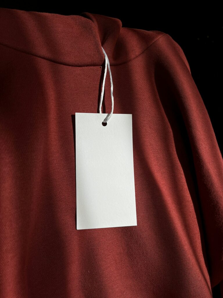 Roupas de qualidade: moletom vermelho de malha com etiqueta branca pendurada