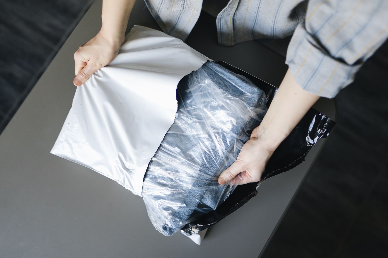 Pessoa abrindo embalagem com peça jeans recebida, exemplo de roupas grátis SHEIN